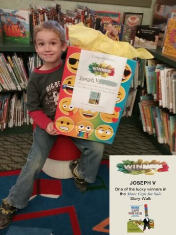 Joseph holds his winner's gift bag featuring More Caps for Sale.